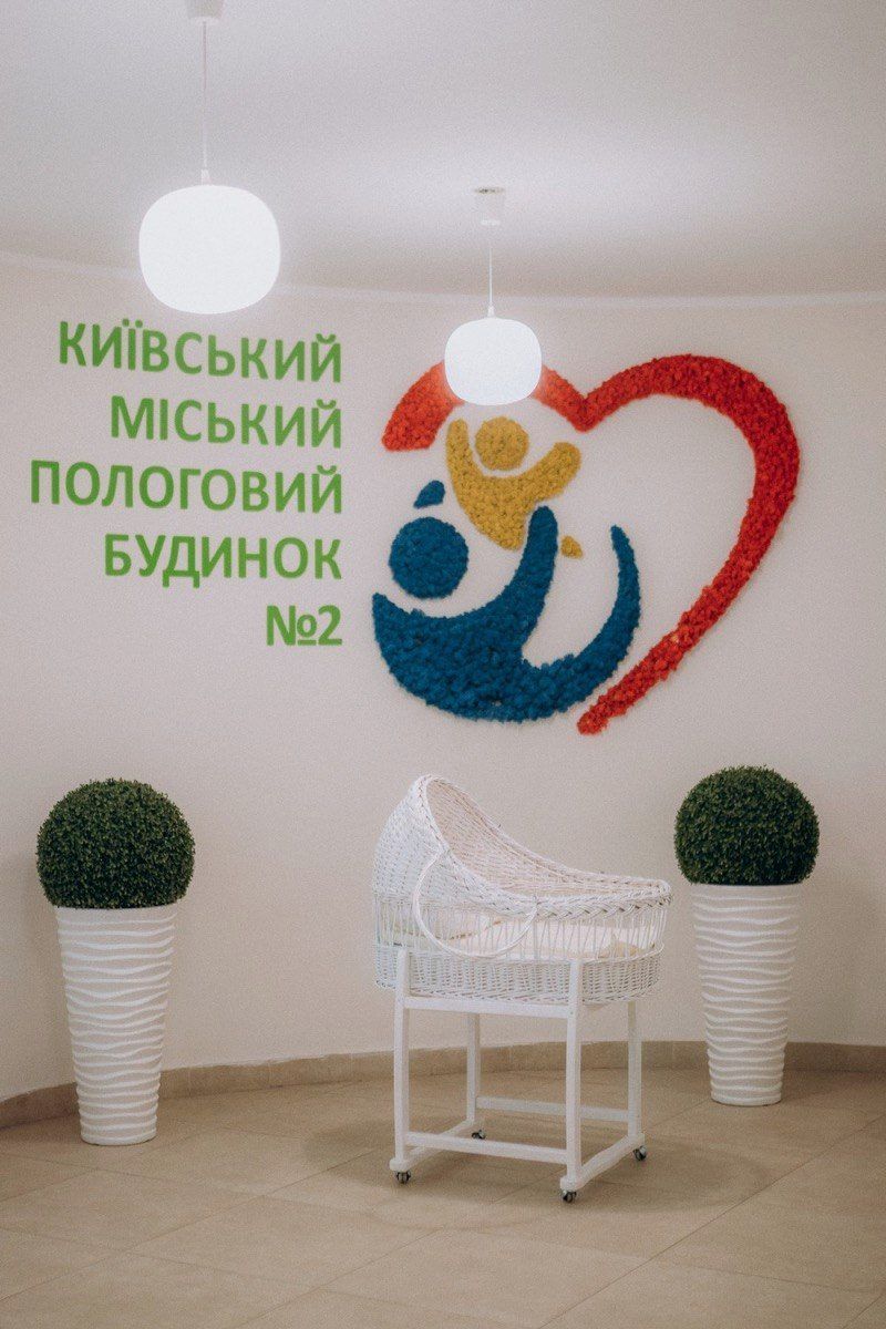 Хол із логотипом пологового будинку і колискою